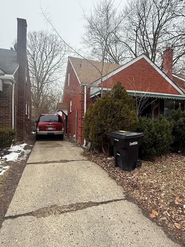 7745 Fielding St, Detroit, MI 48228 - view of side of property featuring concrete driveway and a chimney