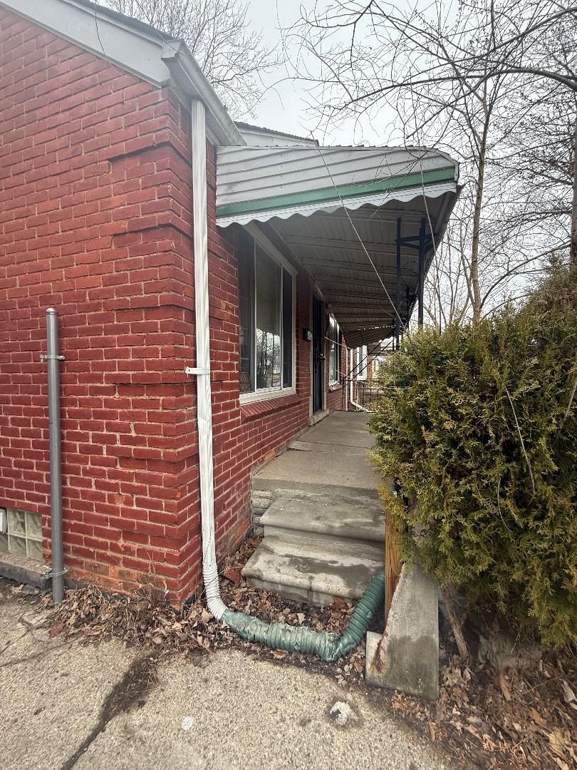 7745 Fielding St, Detroit, MI 48228 - view of side of property with a porch and brick siding