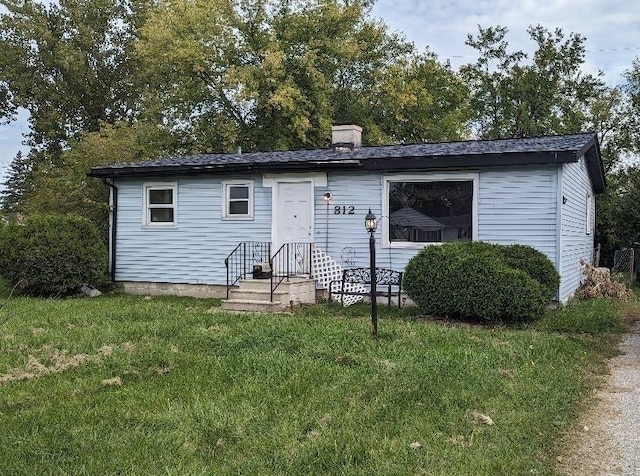 view of front of home featuring a front lawn and a chimney