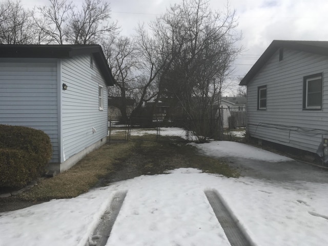 yard covered in snow featuring fence