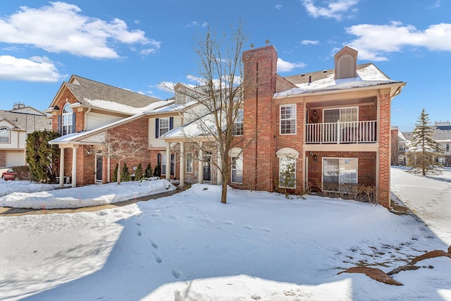 view of front of home with brick siding and a balcony