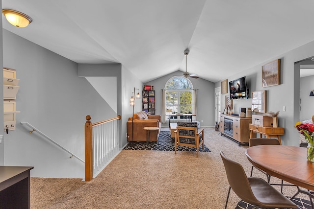 carpeted dining room with ceiling fan and vaulted ceiling