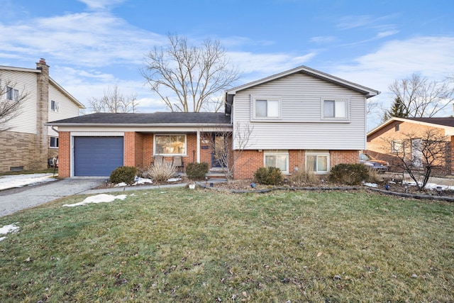 tri-level home with driveway, brick siding, a front lawn, and an attached garage