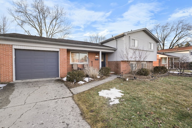 tri-level home with a garage, concrete driveway, brick siding, and a front yard