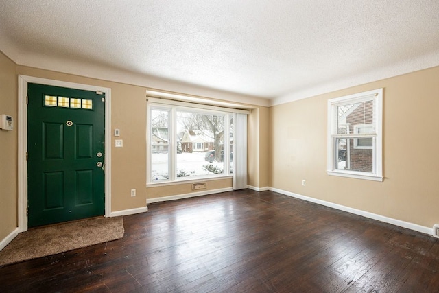 entryway featuring dark wood-style floors, baseboards, and a textured ceiling