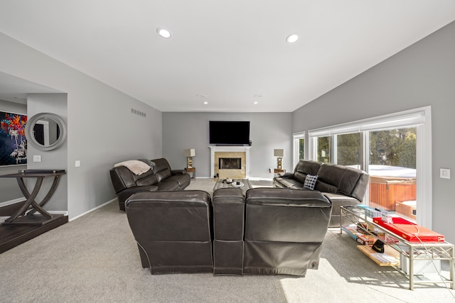 carpeted living area with a fireplace, recessed lighting, lofted ceiling, visible vents, and baseboards