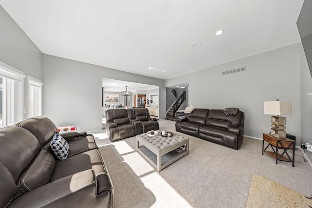 carpeted living area with recessed lighting, a notable chandelier, visible vents, baseboards, and stairway