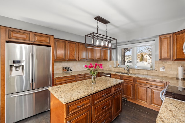 kitchen featuring brown cabinets, dark wood-style floors, stainless steel appliances, and a sink