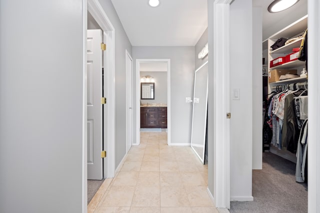 hall with baseboards and light tile patterned flooring