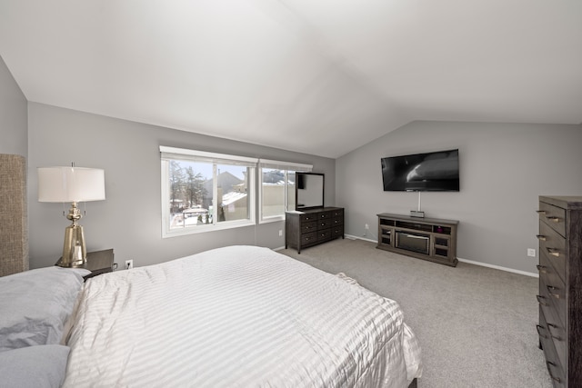 bedroom featuring light carpet, lofted ceiling, and baseboards