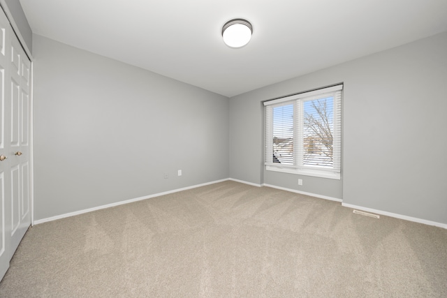 unfurnished bedroom featuring carpet, baseboards, and a closet