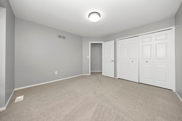 unfurnished bedroom featuring carpet, a closet, visible vents, and baseboards