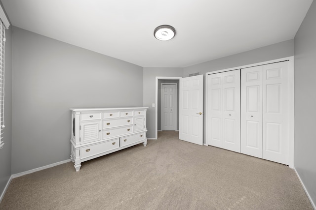 unfurnished bedroom with a closet, carpet flooring, visible vents, and baseboards