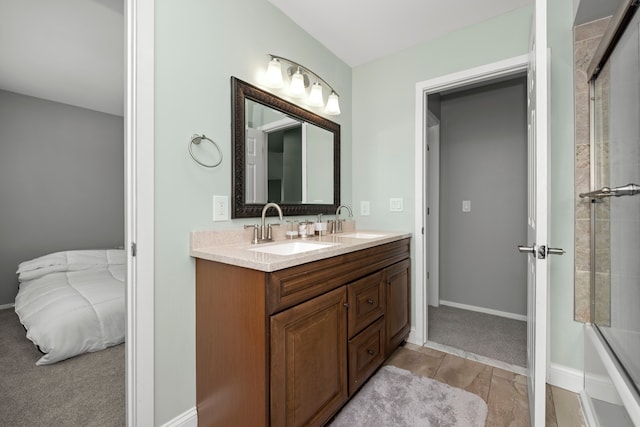 full bath featuring a sink, baseboards, and double vanity