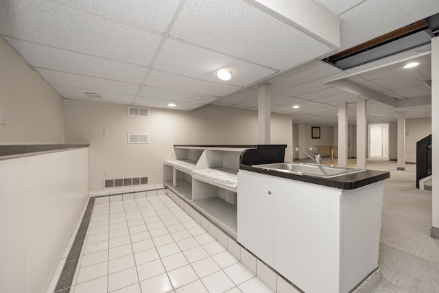 kitchen featuring light tile patterned flooring, a sink, visible vents, open floor plan, and dark countertops