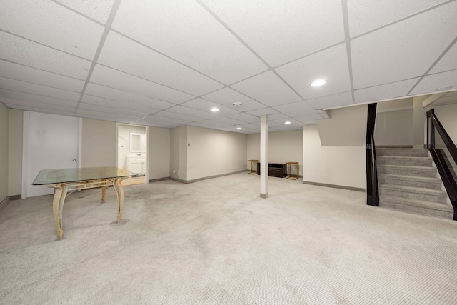 finished basement featuring a drop ceiling, recessed lighting, carpet flooring, baseboards, and stairway