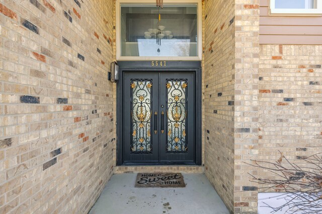 view of exterior entry with french doors and brick siding