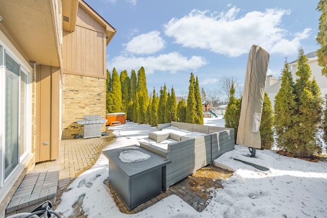 snow covered patio featuring a jacuzzi, outdoor lounge area, and area for grilling