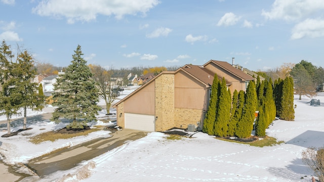 view of snow covered exterior with a garage