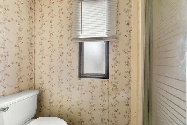 bathroom with toilet and wallpapered walls