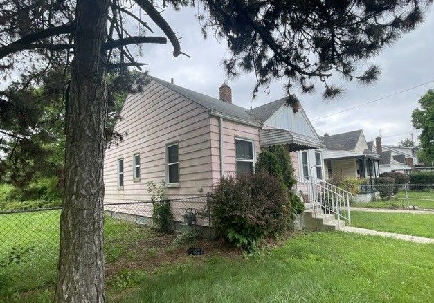 view of property exterior featuring a lawn, a chimney, and fence