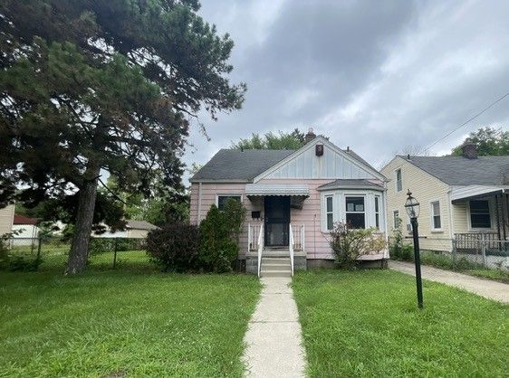 bungalow-style house with a front yard and fence