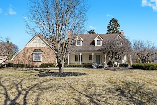 cape cod house with a porch, a chimney, and a front yard