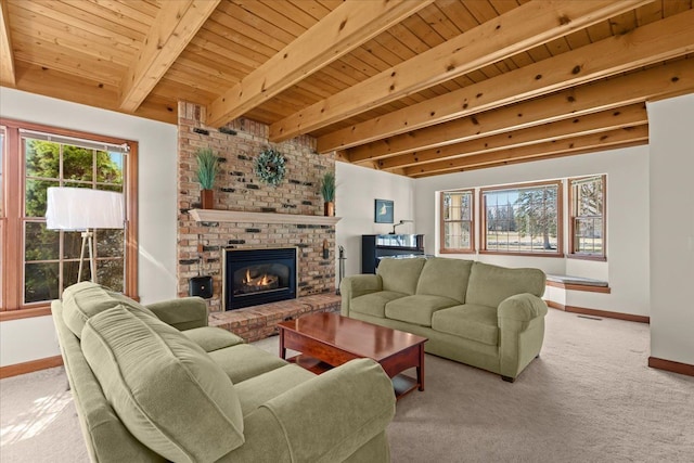 carpeted living room with beam ceiling, baseboards, a brick fireplace, and wooden ceiling