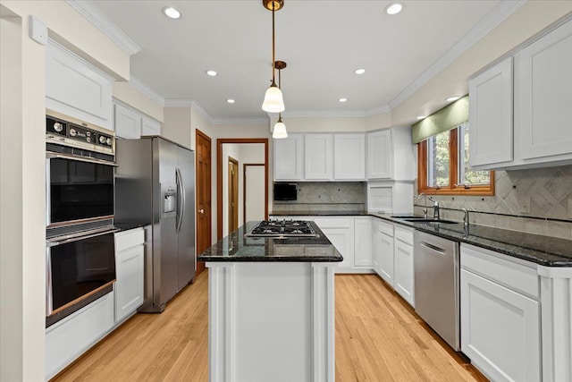 kitchen featuring a sink, a center island, white cabinetry, dark stone counters, and appliances with stainless steel finishes