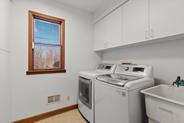 laundry area featuring visible vents, independent washer and dryer, a sink, cabinet space, and baseboards