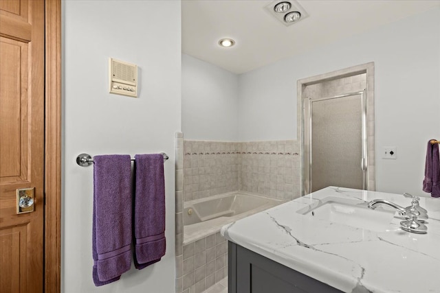 bathroom featuring a garden tub, a stall shower, and vanity