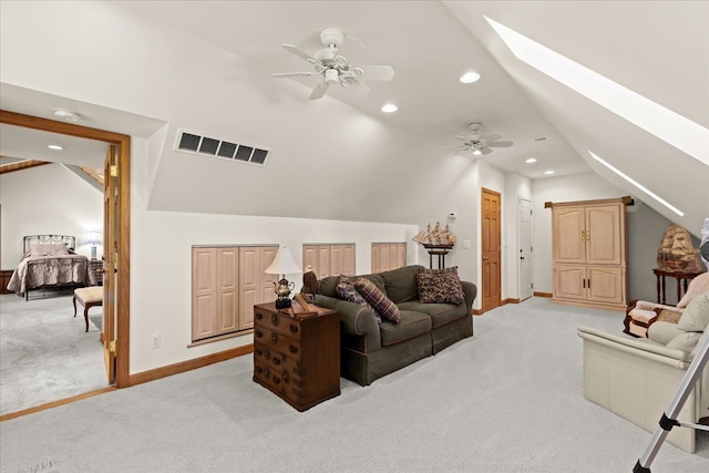 living room with visible vents, baseboards, lofted ceiling with skylight, light carpet, and recessed lighting