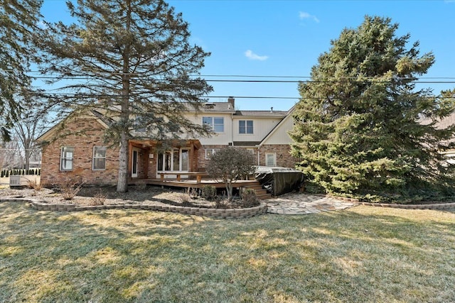 back of property with a lawn, brick siding, and a wooden deck