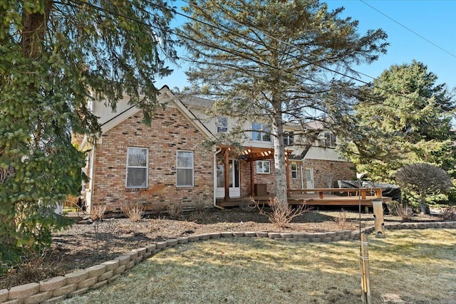 view of front facade featuring a front lawn, brick siding, and a wooden deck
