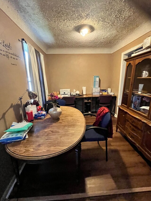 dining room featuring a textured ceiling and wood finished floors