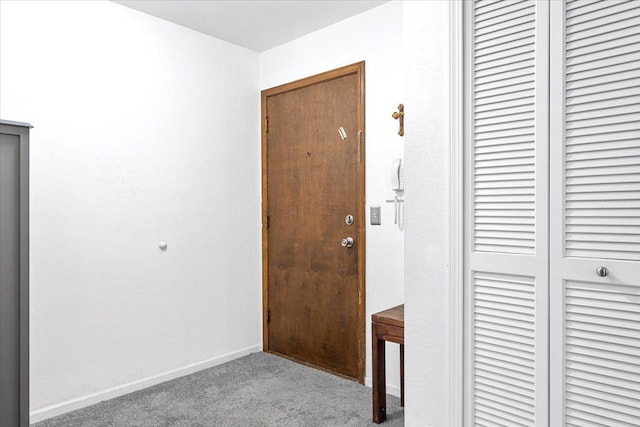 hallway with carpet floors and baseboards