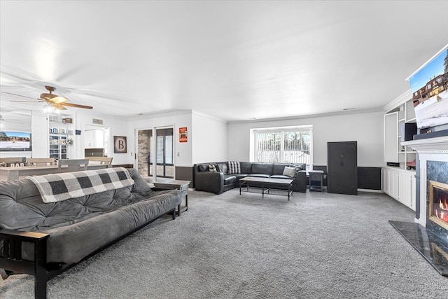 carpeted living area with a premium fireplace and crown molding