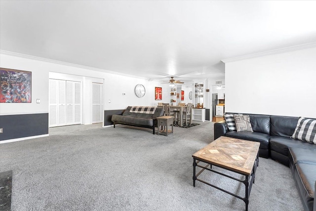 carpeted living area with ornamental molding and a ceiling fan