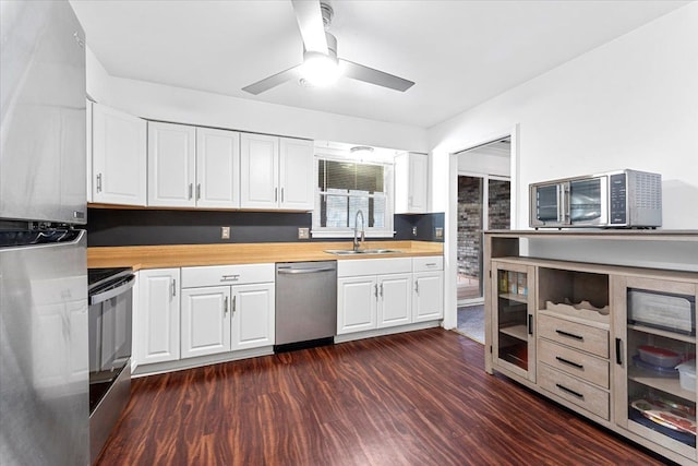 kitchen featuring appliances with stainless steel finishes, dark wood-style flooring, butcher block countertops, and a sink