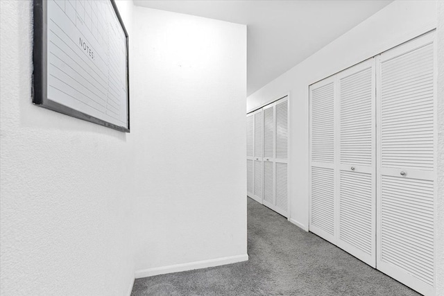 hallway featuring carpet and baseboards