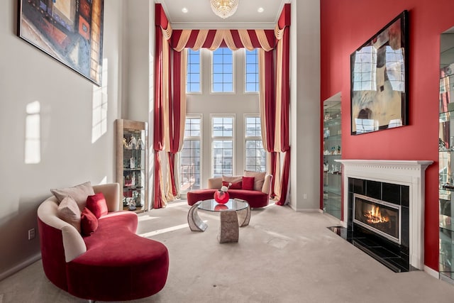 sitting room featuring ornamental molding, a tiled fireplace, carpet flooring, and a wealth of natural light