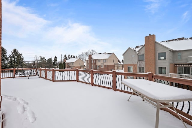 snow covered deck featuring a residential view