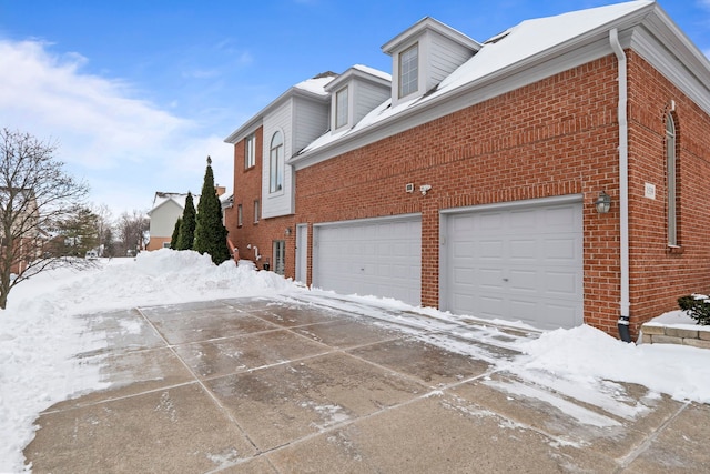 view of snow covered exterior with brick siding