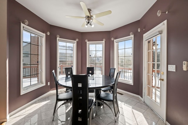 dining space featuring ceiling fan and baseboards