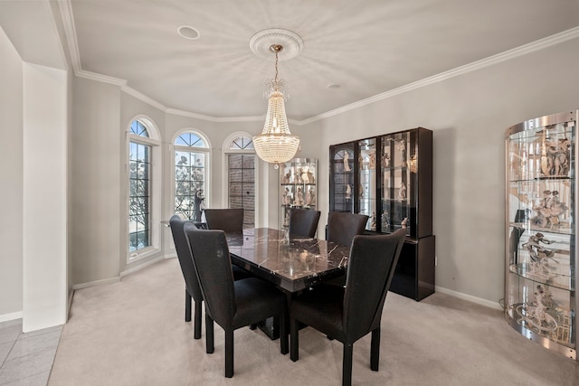 dining space with baseboards, ornamental molding, an inviting chandelier, and light colored carpet