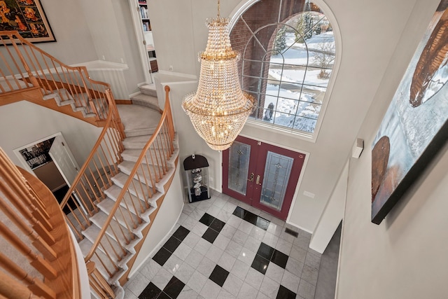 foyer entrance featuring a chandelier, french doors, visible vents, and stairway