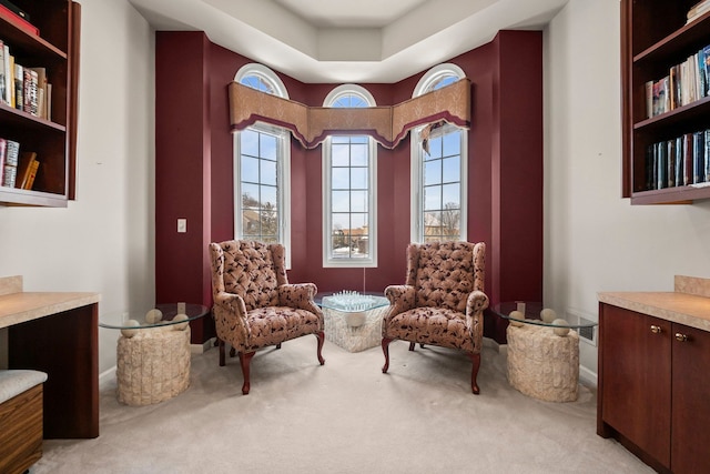 living area with light carpet, plenty of natural light, and baseboards