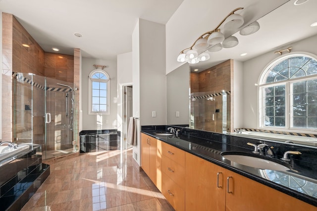 full bath with a stall shower, a garden tub, a sink, and double vanity