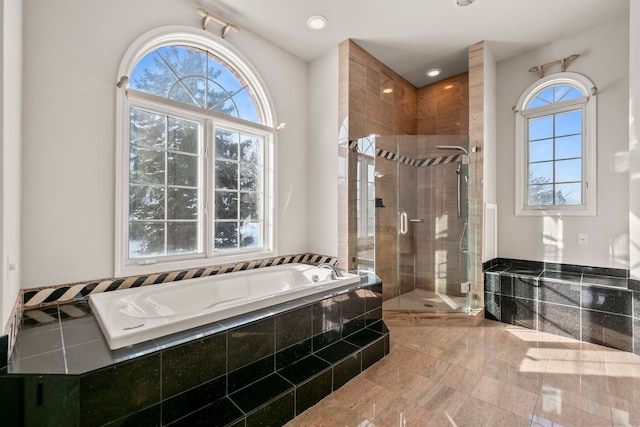 bathroom with a stall shower, a garden tub, and recessed lighting