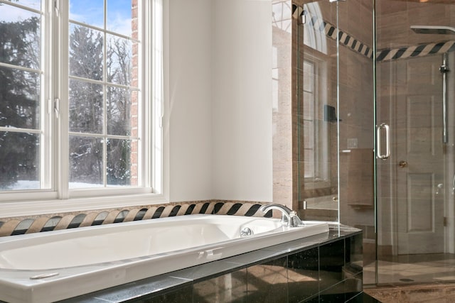 full bathroom featuring a shower stall and a bath